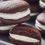 Delicious whoopie pies on a plate, showcasing chocolate and cream filling.