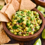 Fresh avocado salsa with tomatoes, onions, and cilantro served in a bowl