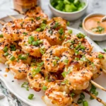 Bang Bang Shrimp Skewers served on a plate with a spicy dipping sauce