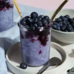 Blueberry milk chia pudding topped with fresh blueberries and coconut flakes.