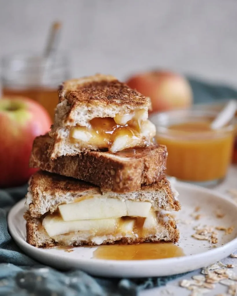 Caramel apple grilled cheese sandwich topped with melted cheese and caramel drizzle.