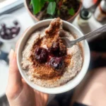 A bowl of Cherry Pie Chia Pudding topped with cherries and almond slices.