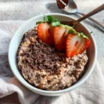 Chocolate peanut butter overnight oats in a jar topped with chocolate chips and peanuts