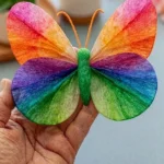 Colorful DIY coffee filter butterflies created by kids in a fun craft project.