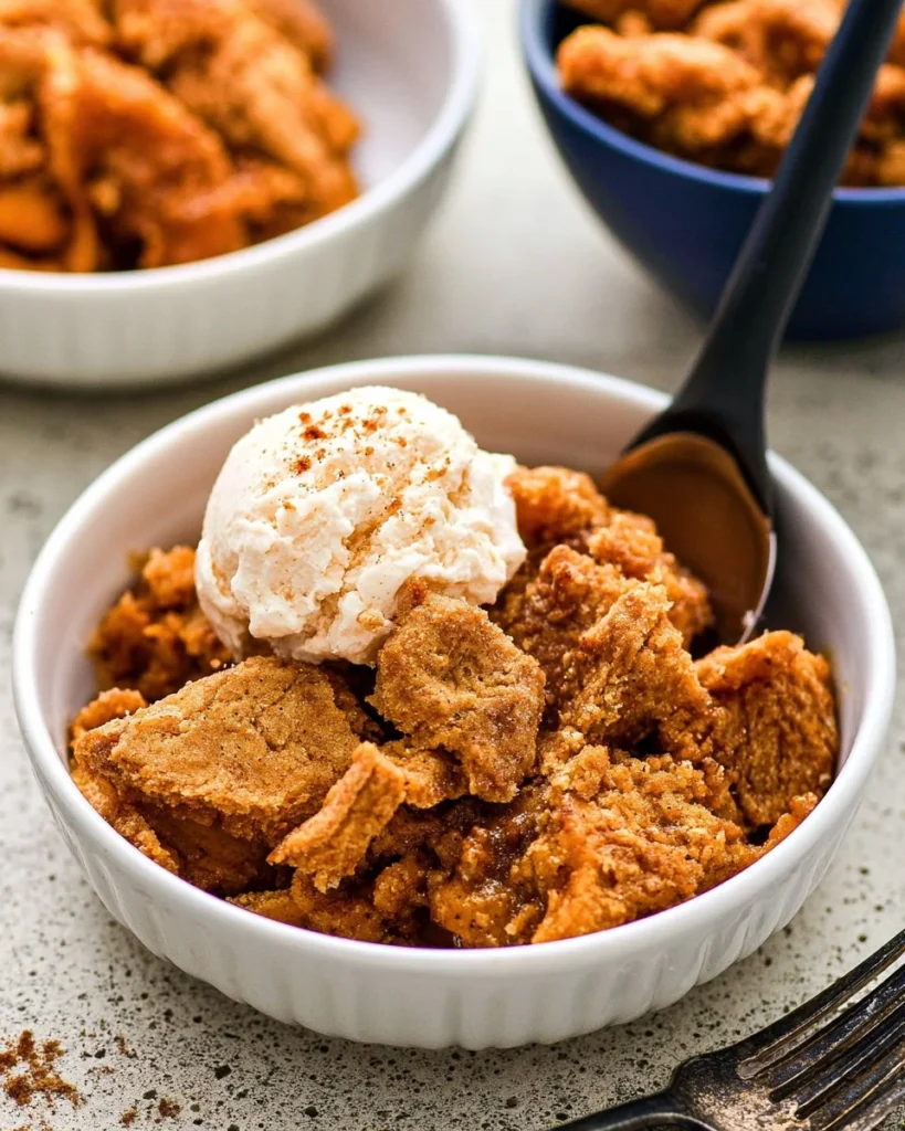 Delicious Crockpot Pumpkin Crumble dessert topped with whipped cream.