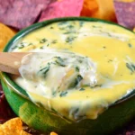 Creamy Easy Shrimp and Spinach Queso Dip served in a bowl with tortilla chips