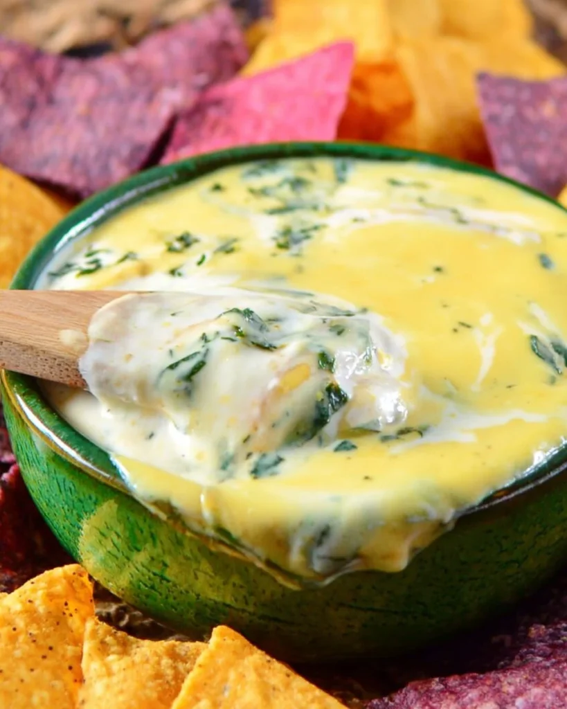 Creamy Easy Shrimp and Spinach Queso Dip served in a bowl with tortilla chips