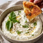 Creamy feta dip served in a bowl, garnished with herbs