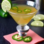 Jalapeno martini garnished with fresh jalapenos and herbs