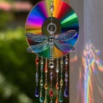Rainbow CD Dragonfly Sun Catcher glowing with colorful reflections