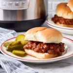 Slow cooker sloppy joes in a bowl on a wooden table.