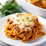 Delicious spaghetti pie served on a plate, garnished with herbs