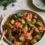 Delicious stewed okra and tomatoes served in a bowl with herbs