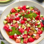 Watermelon salad with cucumber and feta cheese garnished with mint leaves