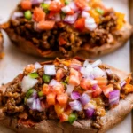 Ground beef stuffed sweet potatoes topped with cheeseburger ingredients